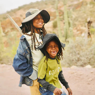 Two children outdoors wearing hats